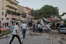 Ľudia sa po zemetrasení v Sindirgi v západnej provincii Balikesir v Turecku ponáhľajú k zrútenej budove, aby hľadali pozostalých. FOTO: Reuters