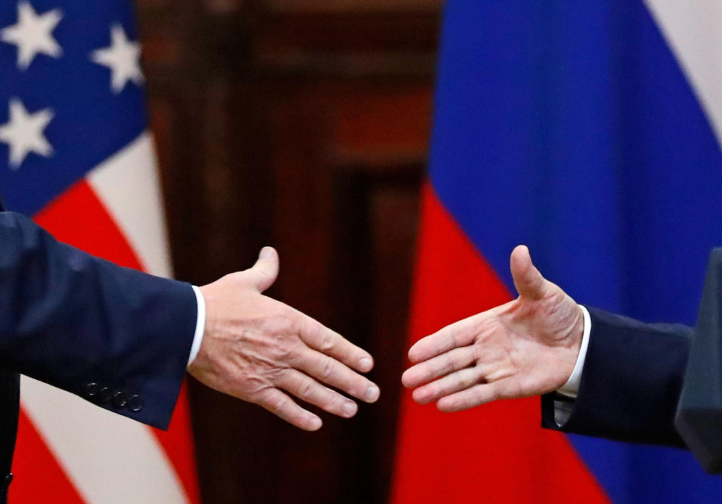 Na archívnej snímke zo 16. júla 2018 zľava americký prezident Donald Trump a ruský prezident Vladimir Putin si podávajú ruky na záver tlačovej konferencie v Helsinkách. FOTO: TASR/AP