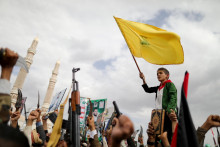 Chlapec drží vlajku Hizballáhu. FOTO: Reuters