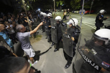 Účastník protivládneho protestu sa rozpráva s policajtami v Belehrade. FOTO: TASR/AP