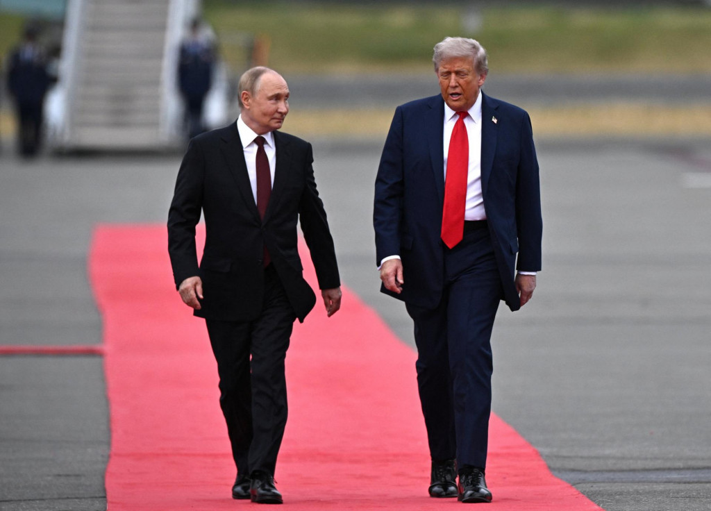 Americký prezident Donald Trump a ruský prezident Vladimir Putin kráčajú po červenom koberci v meste Anchorage na Aljaške. FOTO: Reuters
