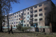 Obyvateľ sa prechádza v blízkosti bytového domu zasiahnutého ruským dronom v meste Bilozerske v Doneckej oblasti na Ukrajine. FOTO: Reuters