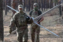 Na snímke z videa zverejnenej ruským ministerstvom obrany ruskí vojaci nesú Lancet dron pred vystrelením na ukrajinské pozície na neznámom mieste na Ukrajine. FOTO: TASR/AP
