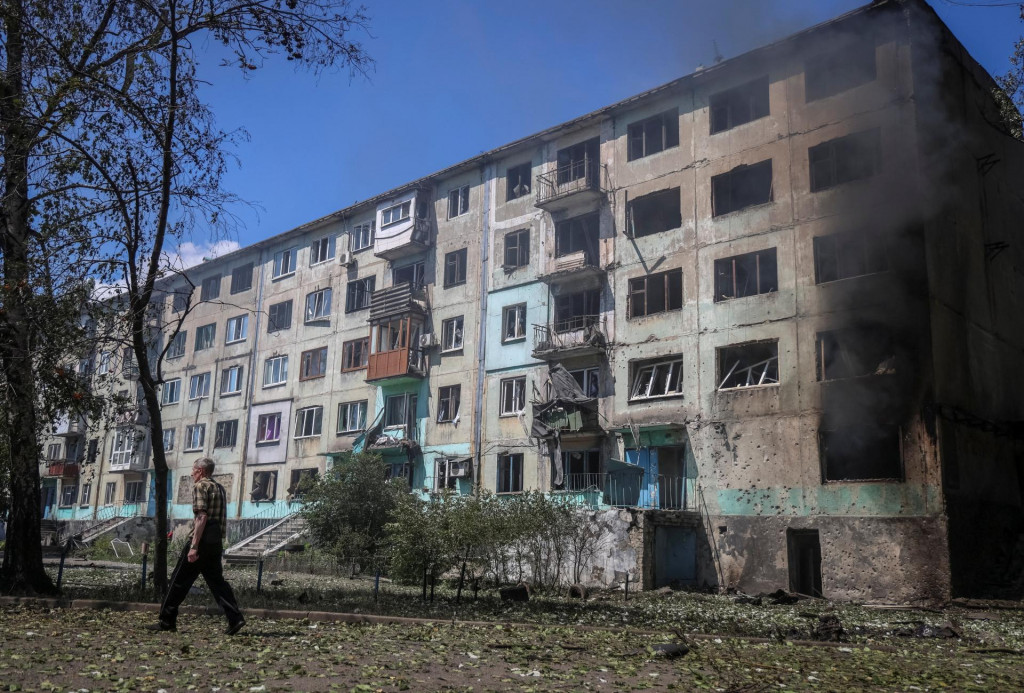 Obyvateľ sa prechádza v blízkosti bytového domu zasiahnutého ruským dronom v meste Bilozerske v Doneckej oblasti na Ukrajine. FOTO: Reuters