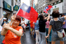 Osoba pózuje na fotografii s taiwanskou vlajkou. FOTO: Reuters