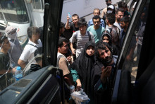 Afganci, ktorí boli deportovaní z Iránu, čakajú na nástup do autobusu po príchode na hraničný priechod Islam Qala. FOTO: Reuters