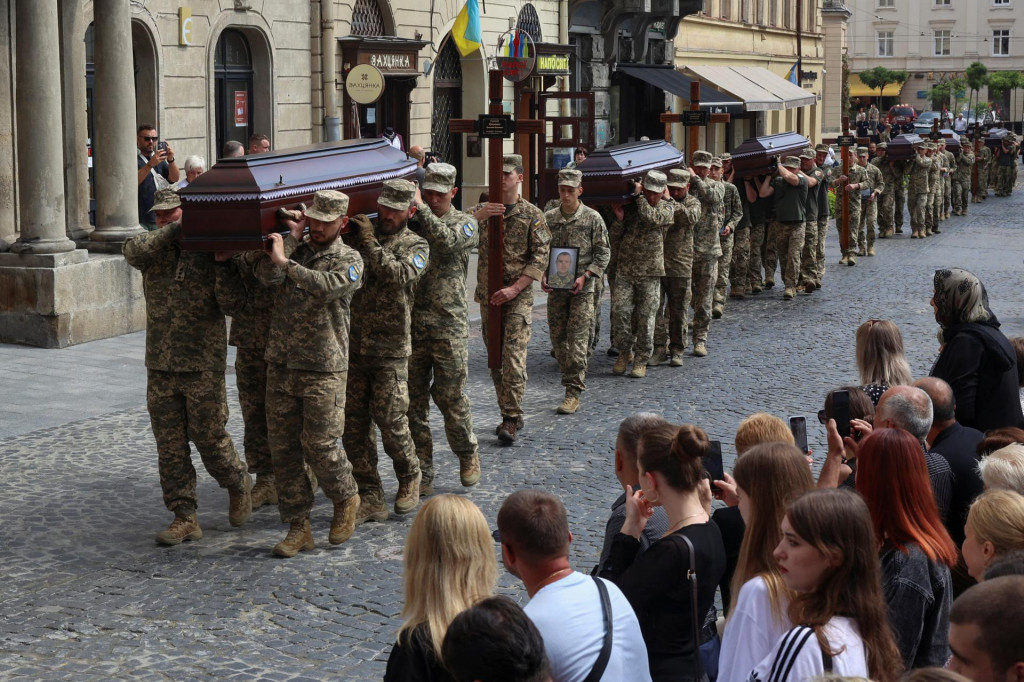 Ukrajinskí vojaci nesú rakvy s telami svojich spolubojovníkov, ktorí zomreli v ruskom zajatí. FOTO: Reuters