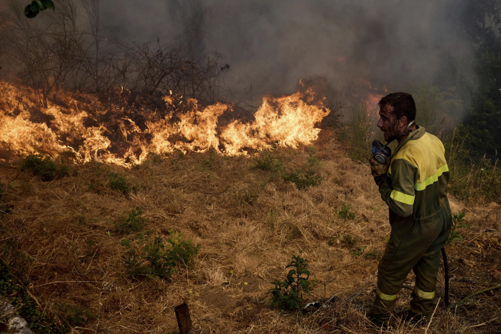 Hasič hasí lesný požiar, ktorý sa naďalej šíri neďaleko dedinky Rebordondo na severozápade Španielska. FOTO: TASR/AP
