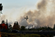 Vodný bombardér sa snaží uhasiť požiar, ktorý spôsobil evakuáciu neďaleko jazera Bayers na okraji Halifaxu v Novom Škótsku v Kanade. FOTO: Reuters