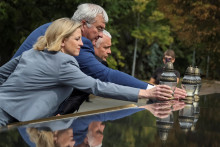 Rakúska ministerka zahraničných vecí Beate Meinl-Reisingerová, ukrajinský minister zahraničných vecí Andrij Sybiha a vedúci Odeskej regionálnej vojenskej správy Oleh Kiper kladú sviečky pri pamätníku padlých ukrajinských obrancov v Odese. FOTO: Reuters