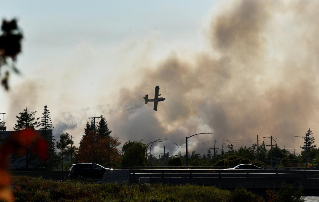 Vodný bombardér sa snaží uhasiť požiar, ktorý spôsobil evakuáciu neďaleko jazera Bayers na okraji Halifaxu v Novom Škótsku v Kanade. FOTO: Reuters