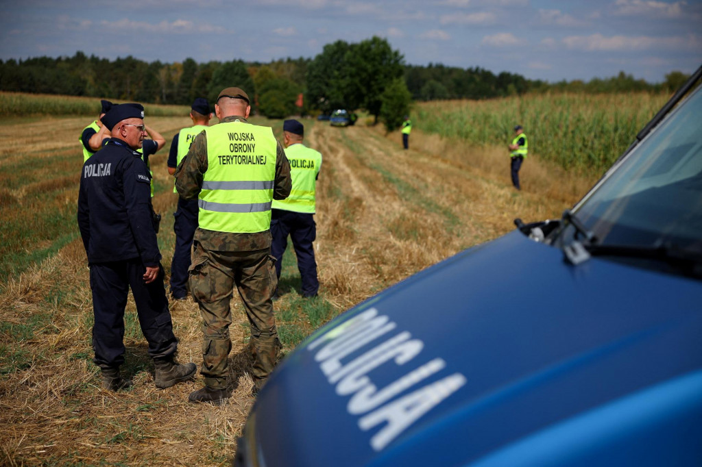 Polícia a jednotky územnej obrany zabezpečujú oblasť po tom, čo v noci v kukuričnom poli v obci Osiny vo východnom Poľsku spadol a explodoval neidentifikovaný predmet. FOTO: Reuters