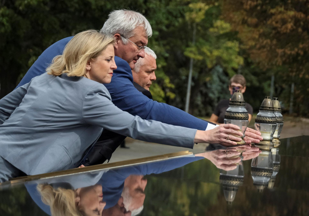 Rakúska ministerka zahraničných vecí Beate Meinl-Reisingerová, ukrajinský minister zahraničných vecí Andrij Sybiha a vedúci Odeskej regionálnej vojenskej správy Oleh Kiper kladú sviečky pri pamätníku padlých ukrajinských obrancov v Odese. FOTO: Reuters