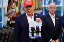 Americk&yacute; prezident Donald Trump drž&iacute; v ruke fotografiu seba a rusk&eacute;ho prezidenta Vladimira Putina zo stretnutia na Alja&scaron;ke. FOTO: Reuters