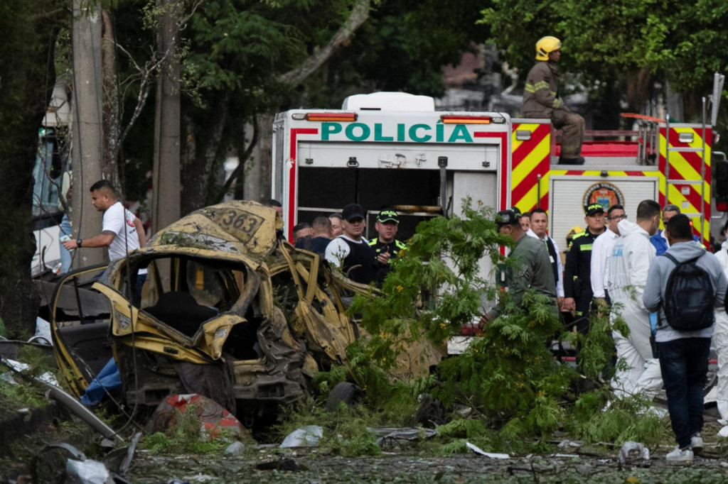 Bezpečnostné sily a členovia forenzného tímu pracujú vedľa trosiek po výbuchu nákladného vozidla neďaleko základne kolumbijských leteckých síl. FOTO: Reuters
