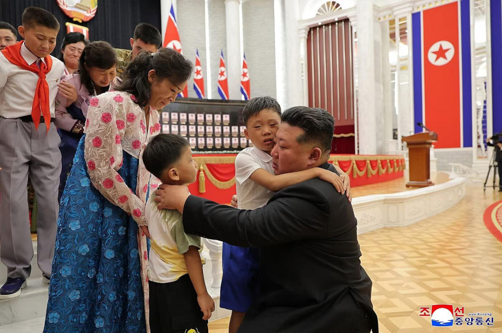 Severokórejský vodca Kim Čong-Un objíma deti vojakov, ktorí padli v boji v ruskej Kurskej oblasti. FOTO: Reuters