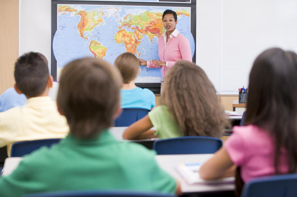 Elementary school teacher with pupils in geography class