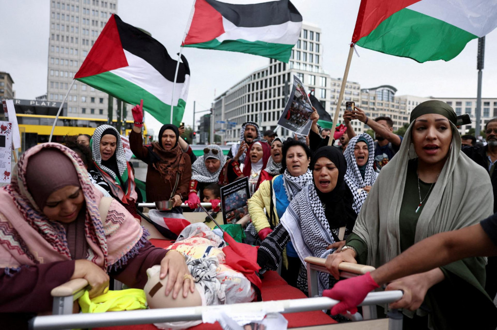 Žena smúti vedľa figuríny symbolizujúcej mŕtvych Palestínčanov, zatiaľ čo ľudia protestujú proti Izraelu a na znak solidarity s palestínskymi deťmi v Gaze v Nemecku. FOTO: Reuters
