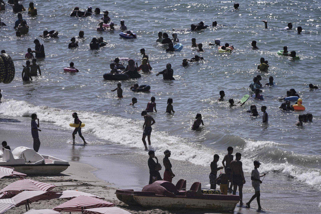 Dovolenkári sa kúpu v Stredozemnom mori počas horúčav pri Alexandrii 20. augusta 2025. FOTO TASR/AP
