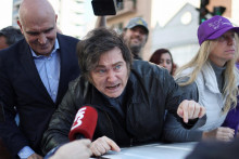 Niektorí ľudia z davu začali hádzať na argentínskeho prezidenta viaceré predmety, pričom aspoň jeden kameň zasiahol kapotu auta. FOTO: REUTERS