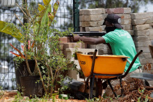 Príslušník bezpečnostných síl komunity zaujíma pozíciu za múrom, zatiaľ čo po operácii haitskej národnej polície a mnohonárodnej bezpečnostnej misie na opätovné dobytie komunikačného strediska Teleco a okolitej komunity z rúk ozbrojených gangov na okraji Port-au-Prince v Kenscoffe na Haiti sú počuť výstrely. FOTO: Reuters