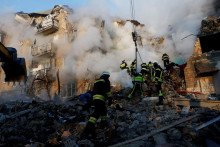 Záchranári pracujú na mieste budovy, ktorú zasiahli ruské raketové útoky a útoky dronmi. FOTO: REUTERS