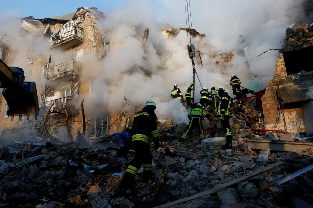 Záchranári pracujú na mieste budovy, ktorú zasiahli ruské raketové útoky a útoky dronmi. FOTO: REUTERS