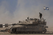 Izraelský vojak stojí na vrchu tanku neďaleko hraníc Izraela s pásmom Gazy. FOTO: TASR/AP