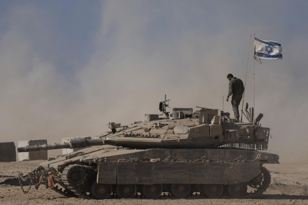 Izraelský vojak stojí na vrchu tanku neďaleko hraníc Izraela s pásmom Gazy. FOTO: TASR/AP