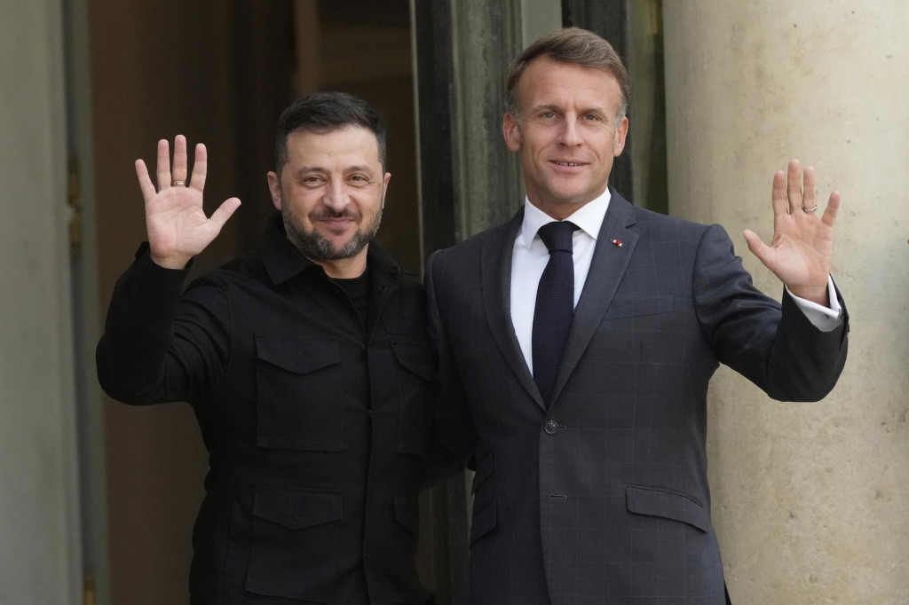 Francúzsky prezident Emmanuel Macron (vpravo) a ukrajinský prezident Volodymyr Zelenskyj mávajú novinárom pred ich stretnutím v Paríži. FOTO: TASR/AP