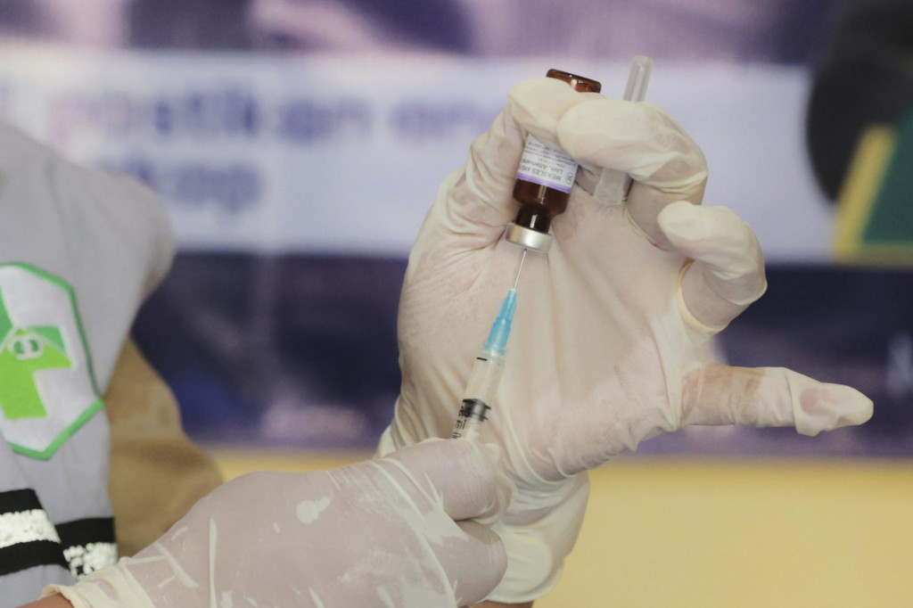 Zdravotník pripravuje vakcínu proti osýpkam počas očkovacej kampane po vypuknutí epidémie v meste Sumenep v Indonézii v pondelok 25. augusta 2025. FOTO TASR/AP