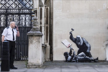 Na nedatovanej snímke od pouličnýho umelca Banksyho, jeho nová nástenná maľba, ktorá sa objavila pred londýnskym súdom. Zobrazuje sudcu, ako neozbrojeného protestujúceho udiera kladivkom. FOTO: TASR/AP