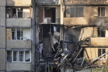 JMiestna obyvateľka sa pozerá z balkóna zničenej obytnej budovy po nočnom ruskom útoku v Kyjeve v nedeľu 7. septembra 2025. FOTO TASR/AP
