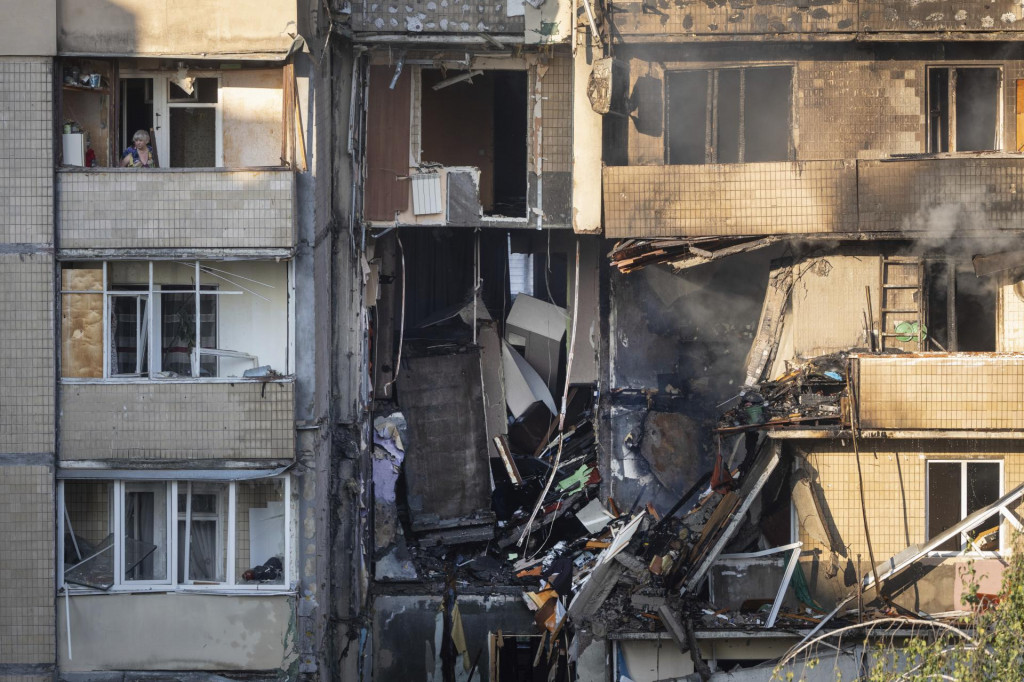 JMiestna obyvateľka sa pozer&aacute; z balk&oacute;na zničenej obytnej budovy po nočnom ruskom &uacute;toku v Kyjeve v nedeľu 7. septembra 2025. FOTO TASR/AP
