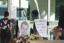 Ľudia kladú kvety pred sídlom organizácie s názvom Turning Point USA v Phoenixe po smrti jej riaditeľa a spoluzakladateľa Charlieho Kirka, ktorého postrelili počas podujatia na univerzite v Oreme v americkom štáte Utah v stredu 10. septembra 2025. FOTO TASR/AP