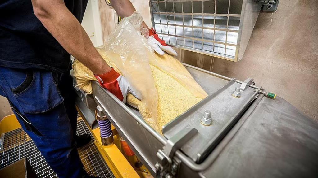 Trinitrotoluén pri nasypávaní do násypky, z ktorej je presne odmeriavaná náplň do delostreleckých nábojov. FOTO: Mafra/Radek Vebr