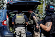 Federálni agenti z Imigračného a colného úradu vykonávajú inšpekčnú operáciu po zadržaní migranta. FOTO: Reuters