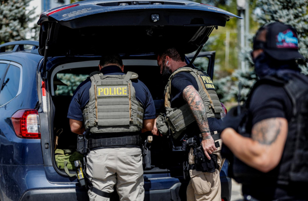 Federálni agenti z Imigračného a colného úradu vykonávajú inšpekčnú operáciu po zadržaní migranta. FOTO: Reuters