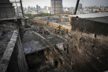 Záchranári odpratávajú trosky na streche zničenej vládnej budovy Úradu vlády po ruskom útoku v Kyjeve. FOTO: TASR/AP