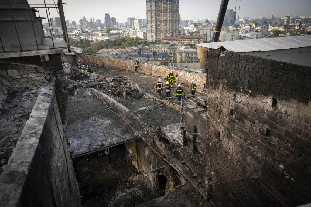Záchranári odpratávajú trosky na streche zničenej vládnej budovy Úradu vlády po ruskom útoku v Kyjeve. FOTO: TASR/AP