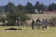Na snímke policajti a príslušníci vojenskej polície zabezpečujú časť úlomkov jedného z dronov, ktoré v noci na stredu narušili vzdušný priestor Poľska, v poľskej dedine Wohyň 10. septembra 2025. FOTO: TASR/AP