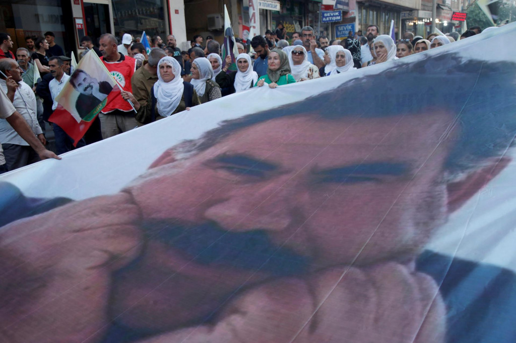 Ľudia pochodujú s transparentom s vyobrazením väzneného kurdského militantného vodcu Abdullaha Öcalana. FOTO: Reuters