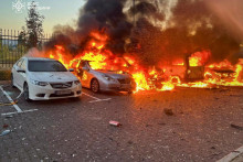 Horiace autá na mieste obytnej budovy poškodenej počas útoku ruského dronu okraji Kyjeva. FOTO: Reuters/Štátna záchranná služba Ukrajiny