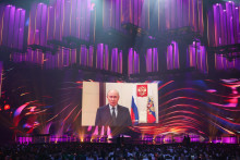 Diváci sledujú video prejav ruského prezidenta Vladimira Putina počas medzinárodnej hudobnej súťaže Intervízia. FOTO: Reuters