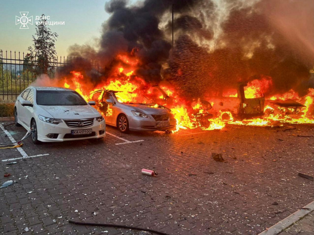 Horiace autá na mieste obytnej budovy poškodenej počas útoku ruského dronu okraji Kyjeva. FOTO: Reuters/Štátna záchranná služba Ukrajiny