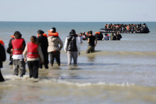 Migranti nastupujú do člnov vo Gravelinese na severe Francúzska a plavia sa do Spojeného kráľovstva. FOTO: TASR/AP