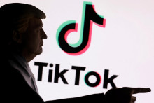 3D tlačený miniatúrny model zobrazujúci amerického prezidenta Donalda Trumpa pred logom TikTok. FOTO: Reuters