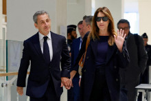 Bývalý francúzsky prezident Nicolas Sarkozy prichádza so svojou manželkou Carlou Bruni-Sarkozy na vynesenie rozsudku. FOTO: Reuters