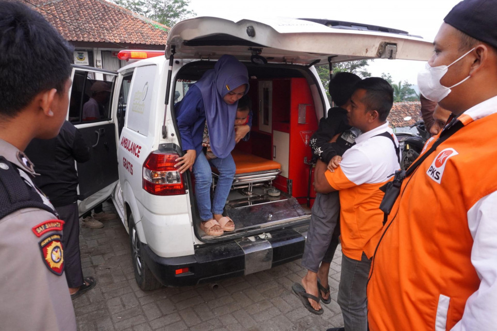 Zdravotnícky pracovník drží na rukách dieťa, ktoré sa otrávilo jedlom v západnej časti provinčnej metropoly Bandung v indonézskej provincií Západná Jáva. FOTO: TASR/AP