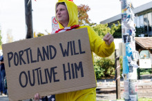 Osoba drží transparent v blízkosti zariadenia Imigračného a colného úradu v deň, keď prezident USA Donald Trump oznámil, že vyšle vojakov do Portlandu. FOTO: Reuters

